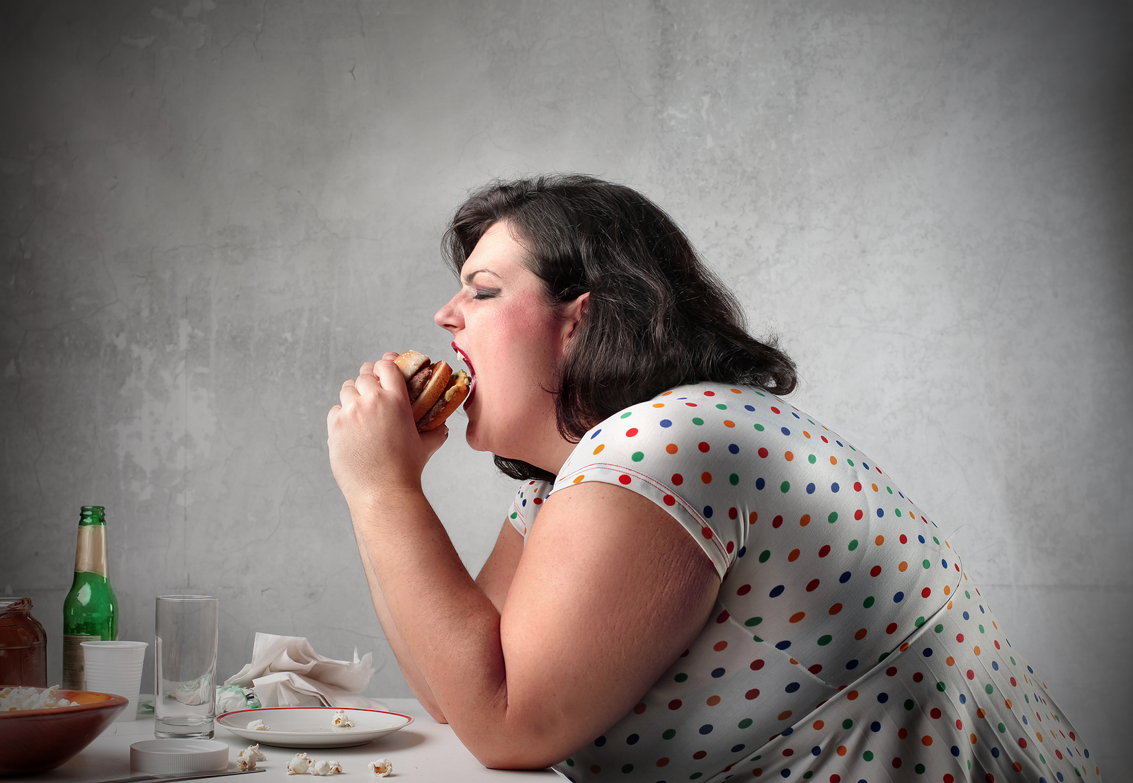 bigstock_Fat_woman_eating_a_hamburger_121636611